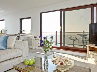 a living room with a couch and a table at Hawks Ridge in Downderry