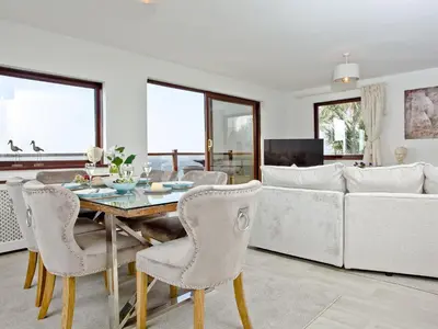 a living room with a table and a couch at Hawks Ridge in Downderry