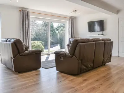 a living room with two chairs and a flat screen tv at Caddie - Uk11038 in Carlyon Bay