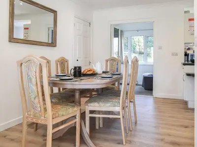 a dining room table with chairs and a mirror at Caddie - Uk11038 in Carlyon Bay
