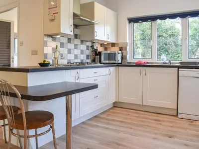 a kitchen with white cabinets and a counter top at Caddie - Uk11038 in Carlyon Bay