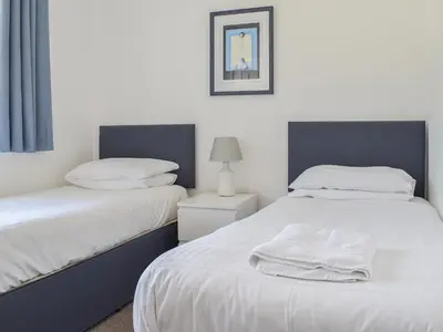 a bedroom with two beds with white sheets and a lamp at Caddie - Uk11038 in Carlyon Bay