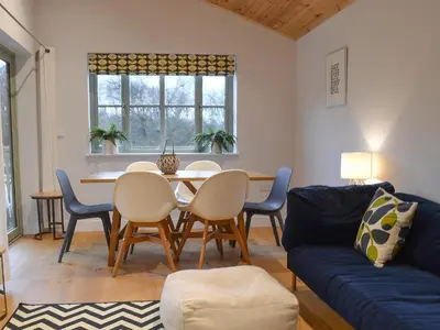 a living room with a table and chairs and a couch at Hen Harrier Lodge-Uc3979 in Saint Columb Major