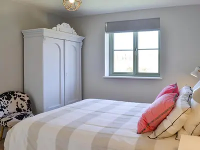 a bedroom with a bed and a window at Hen Harrier Lodge-Uc3979 in Saint Columb Major