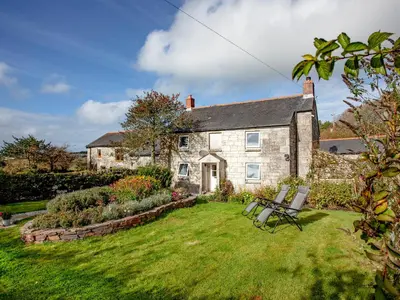 an old stone house with a bench in the yard at Greenbank Farm in Saint Dennis
