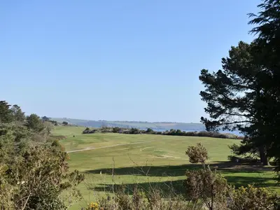 a view of a golf course with trees in the foreground at Bunker - Uk11039 in Carlyon Bay