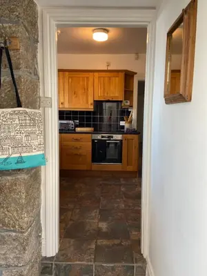 a kitchen with wooden cabinets and a stove top oven at THE STONES St Ives Apartment Panoramic Harbour Views and Onsite Parking in St Ives