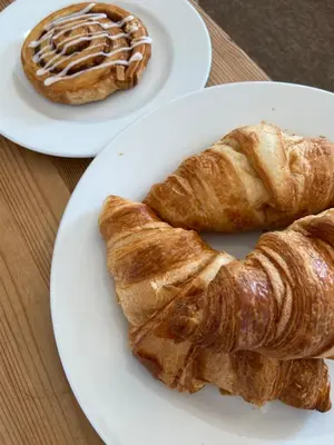 two plates of croissants and a pastry on a table at THE PENTHOUSE Top Floor Apartment with Bay Views, Large Balcony & Onsite Parking in St Ives