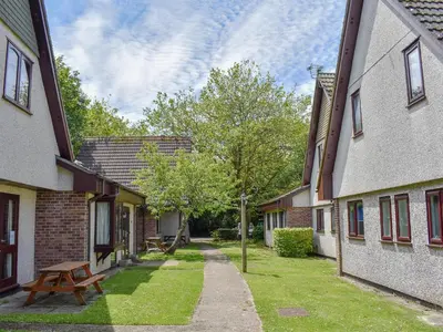 an alley between two buildings with a wooden bench at Trevithick Lodge in Hayle