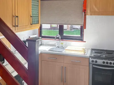 a kitchen with a sink and a stove and a window at Trevithick Lodge in Hayle