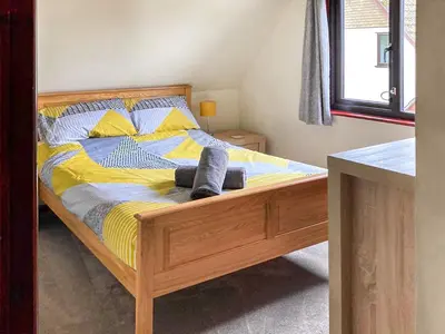 a bedroom with a bed with yellow and blue sheets at Trevithick Lodge in Hayle