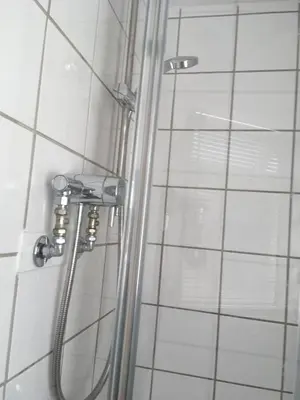 a shower in a bathroom with a glass shower curtain at Great Western Maisonette in Newquay
