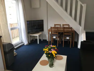 a living room with a vase of flowers on a table at Great Western Maisonette in Newquay