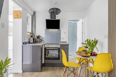 a kitchen with a table and yellow chairs at Waters Edge Holiday Home in Hayle, West Cornwall in Hayle