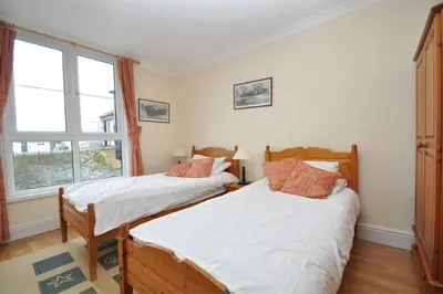 a bedroom with two beds and a window at The Old Quayside House in Falmouth