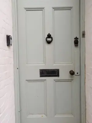 a white door with areath on it next to a brick wall at The Old Quayside House in Falmouth