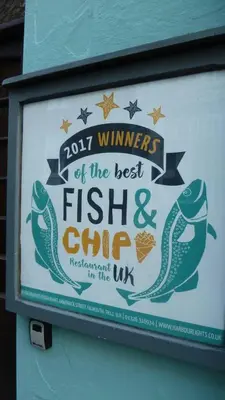 a sign for a fish and chips restaurant in the uk at The Old Quayside House in Falmouth