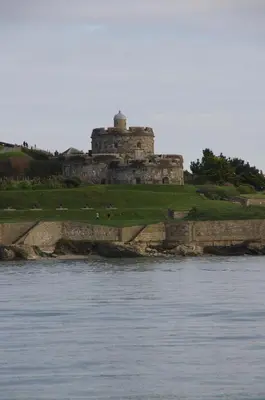 a building on a hill next to a body of water at The Old Quayside House in Falmouth