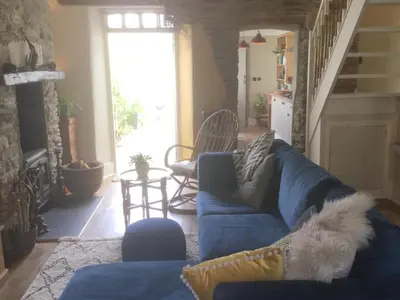 a living room with a blue couch with a dog on it at Bambu Cottage in Newquay