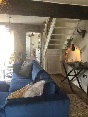 a blue couch in a living room with a staircase at Bambu Cottage in Newquay