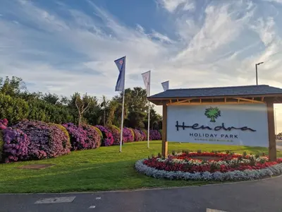a sign for a houston houstonury park with flowers at Hendra Holiday Park in Newquay