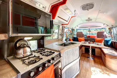 a kitchen in an rv with a stove and a sink at Glamping 1970 American Airstream motorhome in Ponsanooth