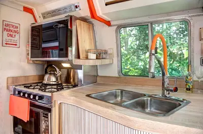 a kitchen in an rv with a sink and a stove at Glamping 1970 American Airstream motorhome in Ponsanooth