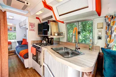a kitchen in an rv with a sink and a stove at Glamping 1970 American Airstream motorhome in Ponsanooth