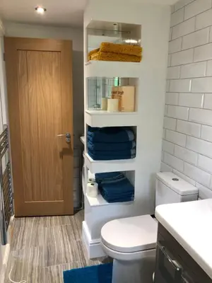 a bathroom with a toilet and a door with towels at Flat 7, Tremorvah Court in Falmouth