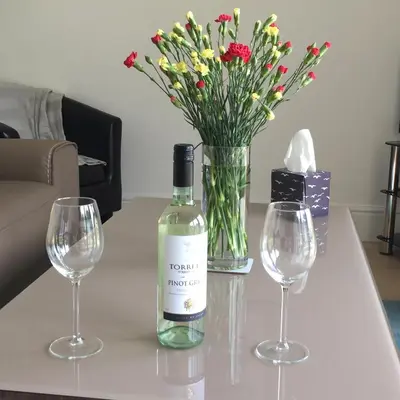a bottle of wine sitting on a table with two wine glasses at Flat 7, Tremorvah Court in Falmouth