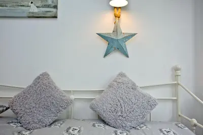 a bed with two pillows and a blue star on the wall at The Barn in Lanhydrock, Bodmin in Bodmin