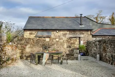 a stone building with a table in front of it at The Barn in Lanhydrock, Bodmin in Bodmin