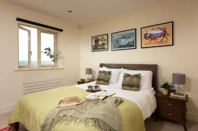 a bedroom with a bed with a green bedspread at 5 The Vista, Newquay - Short Walk to Beach - Free Parking and Wi-Fi - Stunning Views in Newquay