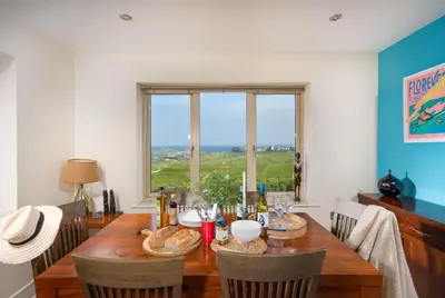 a dining room with a table with chairs and a window at 5 The Vista, Newquay - Short Walk to Beach - Free Parking and Wi-Fi - Stunning Views in Newquay