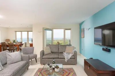 a living room with two chairs and a tv at 5 The Vista, Newquay - Short Walk to Beach - Free Parking and Wi-Fi - Stunning Views in Newquay