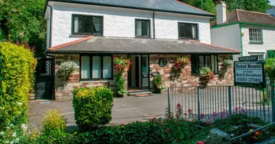 a white house with a sign in front of it at Natal House Bed & Breakfast in Polperro