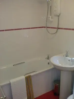 a bathroom with a sink and a bath tub next to a sink at Natal House Bed & Breakfast in Polperro