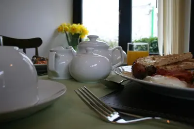 a table with a plate of food and a glass of orange juice at Natal House Bed & Breakfast in Polperro