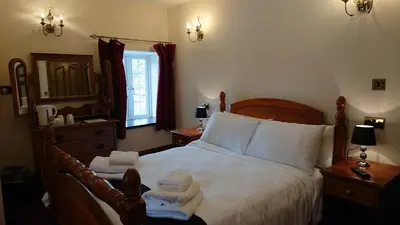 a bedroom with a bed with towels on it at Great Trethew Manor Hotel & Restaurant in Menheniot