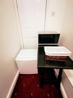 a small room with a table with a microwave at The Darlington Hotel in Camelford