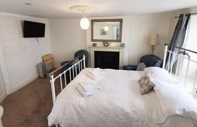 a bedroom with a white bed with two towels on it at The Darlington Hotel in Camelford