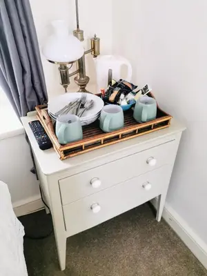 a white dresser with dishes on top of it at The Darlington Hotel in Camelford