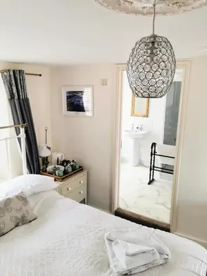 a bedroom with a bed and a mirror and a bathroom at The Darlington Hotel in Camelford
