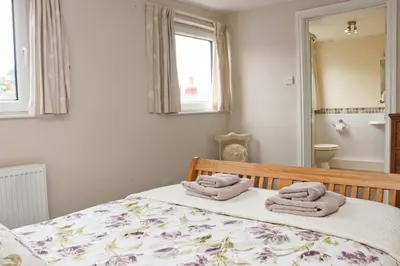 a bedroom with a bed with towels on it at TOWN CENTRE apartment with parking in Padstow