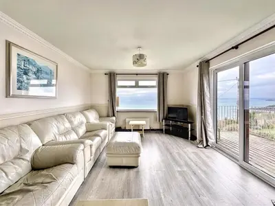 a living room with a white couch and a television at Porthleven Coastal Retreat with 5 Bedrooms in Porthleven