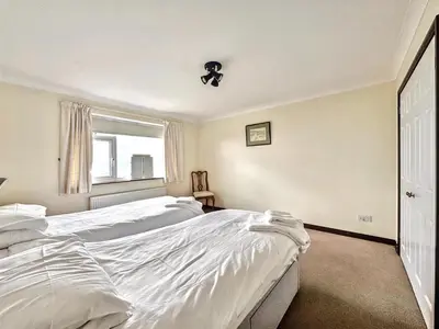 a bedroom with two white beds and a window at Porthleven Coastal Retreat with 5 Bedrooms in Porthleven