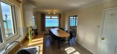 a kitchen with a table and chairs in a room at Porthleven Coastal Retreat with 5 Bedrooms in Porthleven