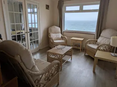 a living room with chairs and a view of the ocean at Porthleven Coastal Retreat with 5 Bedrooms in Porthleven