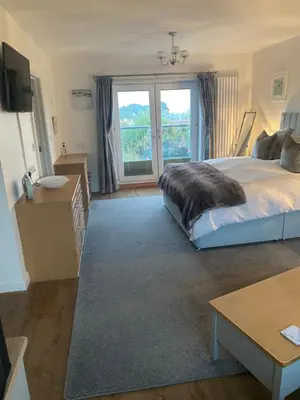 a bedroom with a bed and a large window at Downsfield Bed and Breakfast in St Ives
