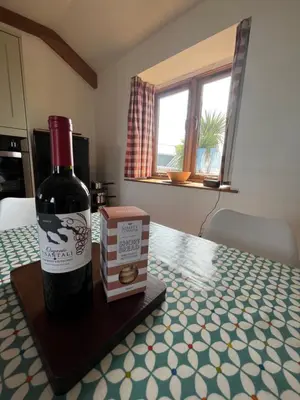 a bottle of wine and a box on a table at The Corn Store in Porthtowan